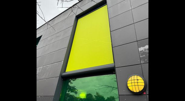 Fassadenrollo mit farbigem Textil im Objektbereich